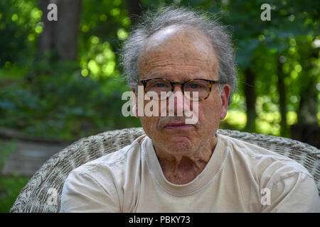 Ernster Mann draußen sitzen Stockfoto