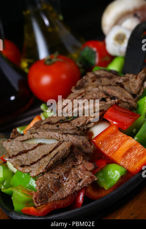 Beef Fajitas mit bunten Paprika in die Pfanne und Tortilla Brot und Soßen Stockfoto