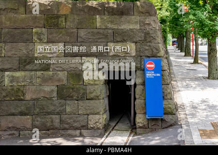 Kleines Loch in der Wand unter dem Zeichen für das Personal Eingang zum National Diet Library, Tokyo, Japan. Stockfoto