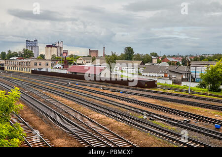 Vitebsk, Belarus - Juli 7, 2018: belarussischen Pflanzen und Eisenbahn im Hintergrund der bewölkten Himmel, gewerbliche Beförderung von Gütern und Personen Stockfoto