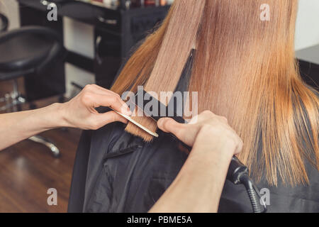 Haarglättung im Beauty Salon. Friseur, eine Frisur für Client mit einem Fön Bügeleisen Stockfoto