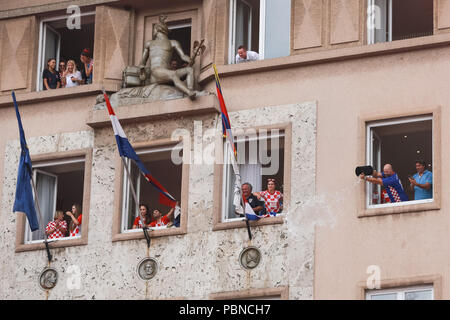 ZAGREB, KROATIEN - 16. JULI 2018: Kroatien Nationalmannschaft willkommen zu Hause feiern. Ein Mann aus dem Fenster des Hotels Dubrovnik wirft, um Wasser zu t cool Stockfoto