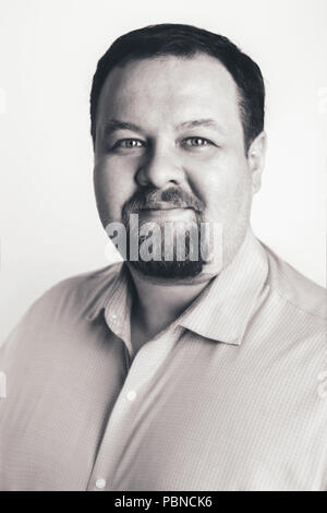 Close-up Schwarz-Weiß-Porträt der kaukasischen Big Fat stout business Mann mit blauen Augen direkt in die Kamera im Studio auf hellen Hintergrund. Kin Stockfoto