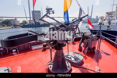 Maschinengewehr auf modernen militärischen Schlachtschiff. Blick auf Zolotoy Brücke über Zolotoy Rog (Goldenes Horn) Bucht im Hintergrund. Russland, Wladiwostok. Stockfoto