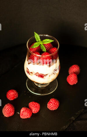 Tiramisu mit Himbeeren in Gläser auf grauem Hintergrund. Drei Teil. Italienisches Dessert. Stockfoto