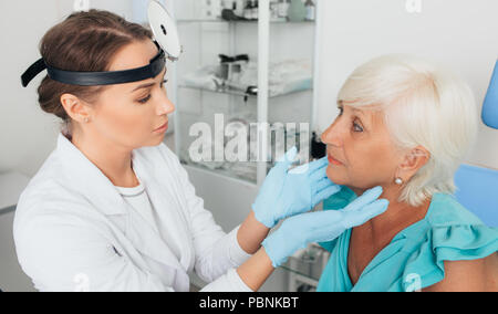 Arzt untersuchen Drüsen des Patienten bei medizinischen Büro Stockfoto