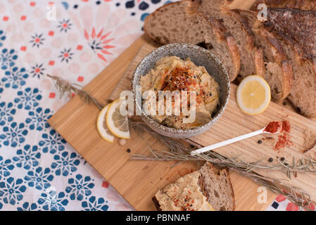 Hummus mit Vollkorn Sauerteigbrot, Paprika und Zitrone Stockfoto