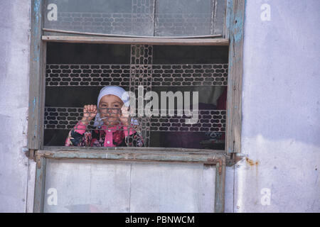 Mädchen im Fenster, Sary Mogul Basar, Kirgisistan Stockfoto