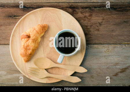 Croissants Kaffee Löffel und Gabel Holz auf dem hölzernen Tisch-ton Vintage Stockfoto