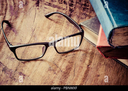 Gläser auf einen Holztisch mit Bücher gesetzt. Stockfoto