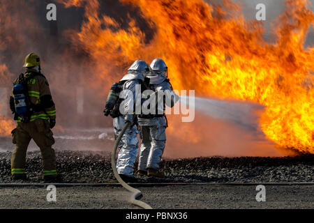 Feuerwehrmänner vom Joint Forces Training Base Feuerwehr in Los Alamitos, Kalifornien, einem simulierten Flugzeugen Feuer zu löschen, April 16, 2018, während des Trainings in Flugzeugen Rettung und Brandbekämpfung Techniken an der San Bernardino regionale Emergency Training Center in San Bernardino, Kalifornien. Die Feuerwehr ist verantwortlich für den Einbau und die Co - Los Alamitos Army Airfield. (U.S. Air National Guard Foto von älteren Flieger Crystal Housman) Stockfoto