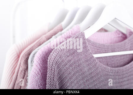 Warme gestrickt, Herbst, Winter Kleidung hängend an einem Rack, trending Konzept, Pastellfarben Stockfoto