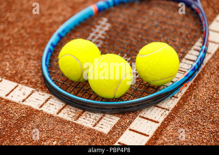 Nahaufnahme von Tennisschläger und Bällen auf dem Sandplatz-tennis Stockfoto