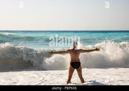 Man jagen die Wellen auf den Strand von Myrtos, Kefalonia, Griechenland Stockfoto