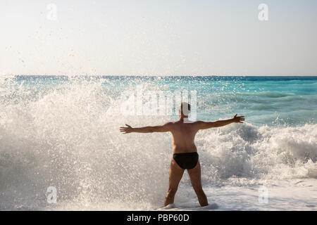 Man jagen die Wellen auf den Strand von Myrtos, Kefalonia, Griechenland Stockfoto