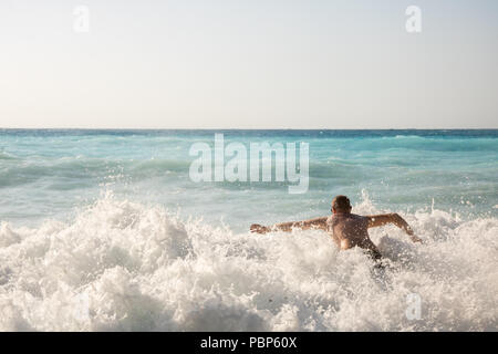 Man jagen die Wellen auf den Strand von Myrtos, Kefalonia, Griechenland Stockfoto