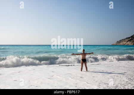 Man jagen die Wellen auf den Strand von Myrtos, Kefalonia, Griechenland Stockfoto