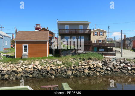 Ein Blick auf die weatherboard Cottages und rot-weiße Leuchtturm im Hafen von Cheticamp auf dem Cabot Trail, Cape Breton Island, Nova Scotia. Stockfoto