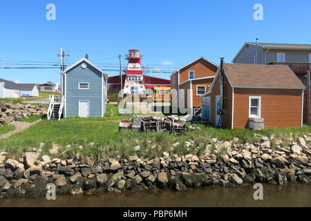 Ein Blick auf die weatherboard Cottages und rot-weiße Leuchtturm im Hafen von Cheticamp auf dem Cabot Trail, Cape Breton Island, Nova Scotia. Stockfoto