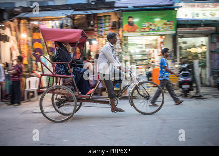 Velo-rikscha versuchen, ein Kunde durch die überfüllten Straßen von Central New Delhi zu fahren. Stockfoto
