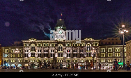 Triest, Italien, vom 28. Juli 2018. Der Vollmond scheint aus den Wolken hinter dem Rathaus von Triest an der Piazza Unità d'Italia. Die Zahlen, die Stockfoto