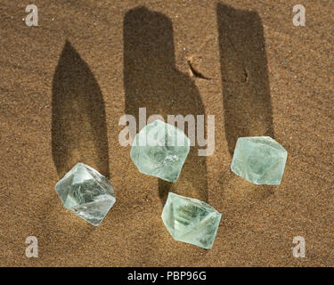 Grüne Fluorit Oktaeder natürliche Kristalle am Strand bei Sonnenaufgang. Stockfoto