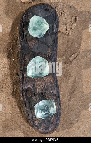 Grüne Fluorit Oktaeder natürliche Kristalle am Strand bei Sonnenaufgang. Stockfoto