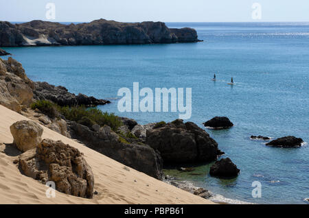 Mittelmeerküste mit blauem Meer und zwei nicht identifizierte Touristen im Abstand eingerückt standup paddleboarding Stockfoto