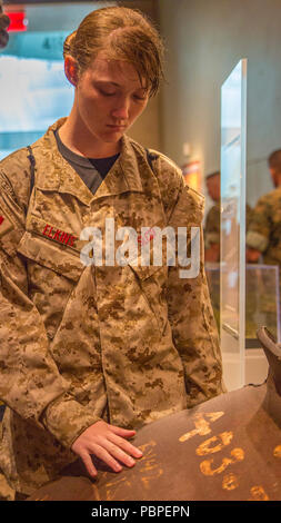 Anna Elkins, Student aus Granbury High School in Granbury, Texas, berührt ein Stück des World Trade Center während der Marine Corps Recruiting Befehl Summer's Leadership 2018 und Charakter Development Academy am nationalen Museum der Marine Corps im Dreieck, Virginia, 21. Juli. Im Laufe der Woche, Studenten wurden herausgefordert, die außerhalb ihrer Komfortzonen zu Schritt und ihr Vertrauen und Führungsqualitäten stärken. Sie hörten von namhaften Führer, darunter Unternehmer, Überlebende des Holocaust und Marines aus allen Lebensbereichen. Die körperliche Fitness wurde auch durch physische betonte Stockfoto