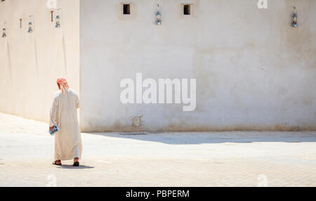 Sharjah, VAE, 26. März 2016: Ein lokaler Mann in einem traditionellen arabischen Kleid auf einer Straße in Sharjah, VAE Stockfoto