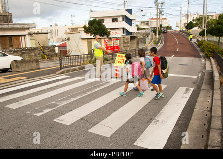 CHATAN STADT, Okinawa, Japan - Oberst Vincent Ciuccoli stoppt Verkehr für Kinder auf ihrem Weg zu Kitatama Volksschule Juli 19 in Chatan Stadt, Okinawa, Japan. Ciuccoli freiwillig als Crossing Guard, um zu helfen, die Volksschule, die Sicherheit der Kinder sorgen, als Sie zu Fuß entlang der geschäftigen Straßen von chatan Stadt zur Schule. Ciuccoli ist der Lagerkommandant von Camp Foster und der Zentrale und den kommandierenden Offizier der Unterstützung Bataillon, Marine Corps Installationen Pacific-Marine Corps Base Camp Butler, Japan. (U.S. Marine Corps Foto von Cpl. Danielle R. Prentice) Stockfoto