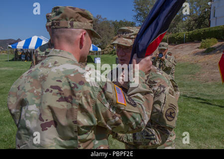 FORT Hunter Liggett, CALIF. - Armee-reserve Brig. Gen. Michael D. Roache, eingehende Kommandant der Pacific Division, 84th Ausbildung erhält den Befehl, die Farben der Division von Generalmajor A. Ray Lizenzgebühren, Kommandierender General des 84th Ausbildung Befehl während der Änderung der Befehl Zeremonie, auf Fort Hunter Liggett, 22. Juli 2018 statt. Die Änderung des Befehls Zeremonie erinnert an roache als stellvertretender Kommandeur der Pacific Division, 84th Ausbildung Befehl, von Brig. Gen. Brently F. Weiß. (U.S. Armee finden Foto von SPC. Sean McCallon) Stockfoto