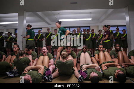 Us Marine Corps Rekruten mit Platoon 4038, Papa, 4 Recruit Training Bataillon, führen Sie Knirschen in der Anfangsphase ihrer Stärke Test auf Parris Island, 20. Juli 2018. Die minimale physische Anforderungen für weibliche Rekruten zu beginnen mit dem Training sind 44 Knirschen in zwei Minuten, 1 Pull-up ohne Zeitangabe oder 15 Push-ups in zwei Minuten, und ein 1,5-Meile laufen in 15 Minuten. Heute, rund 19.000 Rekruten kommen auf Parris Island jährlich für die Chance, United States Marines werden durch dauerhafte 13 Wochen strenge, transformative Training. Parris Island ist die Heimat von Entry-level-Soldaten Training für 49 p Stockfoto