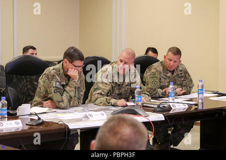 KANDAHAR AIRFIELD, Afghanistan (Juli 25, 2018) - US-Armee General Joseph Votel, Links, Commander für US Central Command, U.S. Army Brig. Gen. Jeffrey Smiley, Mitte, Commander für Zug, Beraten und Unterstützen Command-South und U.S. Army Command Sgt. Maj Anton Hillig, rechts, Senior Soldaten Marktführer für Taac - Süd, die Fähigkeiten von Taac - Süd, 25. Juli 2018 diskutieren, während Votel's Besuch in Kandahar Airfield, Afghanistan. (U.S. Armee Foto von Maj. John Shin) Stockfoto