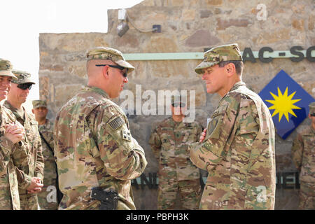 KANDAHAR AIRFIELD, Afghanistan (Juli 25, 2018) --U.S. Army Command Sgt. Maj Anton Hillig, Links, Senior Soldaten Marktführer für Zug, Beraten und Unterstützen Command-South, spricht mit US-Armee General Joseph Votel, rechts, Commander für US Central Command, Juli 25, 2018, bevor eine Münze Siegerehrung in der Taac-Compound in Kandahar Airfield, Afghanistan. (U.S. Armee Foto: Staff Sgt. Neysa Canfield) Stockfoto