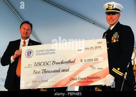 Robert Montgomery, Verwalter der Coast Guard Foundation, präsentiert ein prüfen, Oberstleutnant Bryan Kilcoin, kommandierender Offizier der Coast Guard Cutter Nathan Bruckenthal, bei der Inbetriebnahme des Schiffes Zeremonie in Alexandria, Virginia, 25. Juli 2018. Die Überprüfung wurde für die Moral Fonds des Werkzeugs vorgestellt. (U.S. Coast Guard Foto von Senior Chief Petty Officer Kyle Niemi) Stockfoto