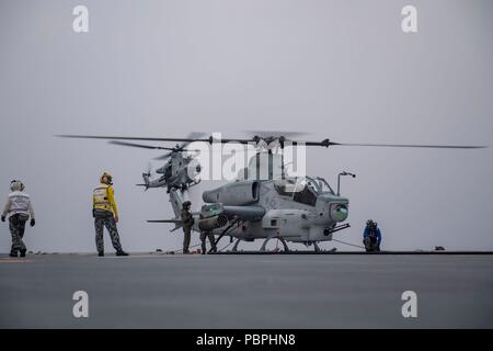 180723-N-VR 594-2449 AUF SEE (23. Juli 2018) Eine AH-1Z Kobra, die den carface' der Marine Light Attack Helicopter Squadron (HMLA) 367, führt deck Landung Qualifikationen auf dem Flugdeck der Royal Australian Navy landing Helicopter dock Schiff HMAS Adelaide (L01) während der Rand des Pazifik (Rimpac) Übung, Juli 23 zugeordnet. Dies ist das erste Mal in Adelaide Flugbetrieb mit Marine AH-1Z Kobras durchgeführt hat. 25 Nationen, 46 Schiffe, 5 U-Boote, und etwa 200 Flugzeugen und 25.000 Angestellte beteiligen sich an Rimpac vom 27. Juni bis 2. August in und um den hawaiischen Inseln Stockfoto