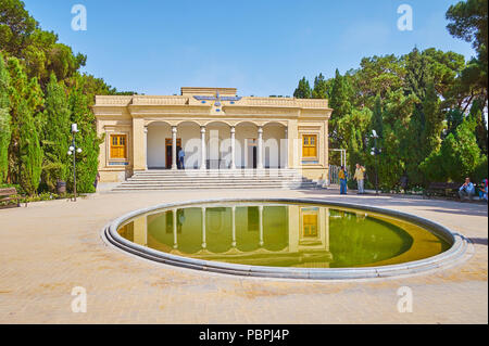 YAZD, IRAN - 18. Oktober 2017: Die Fassade der zoroastrischen Atash Behram (siegreichen Feuer) Tempel mit üppigen grünen Garten rund um it und den kleinen Teich, auf Stockfoto