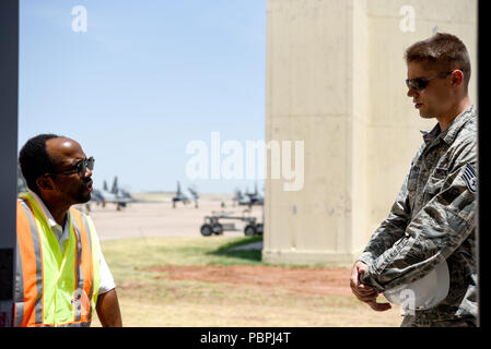 Staff Sgt. Gregory Winfrey, 82nd Squadron Contracting Contracting Officer, spricht mit einem Der führen Fremdfirmen zu Sheppard Air Force Base, Texas, 20. Juli 2018. Waren Winfrey und der Auftragnehmer darüber sprechen, wie die Arbeit am neuen Bürgersteig, in der Nähe des Hangars der 80th Flying Training Wing, zusammen kommt. Winfrey gelegentlich Besuche jede seiner Seiten über die Fortschritte zu prüfen, die die Auftragnehmer, die er angestellt hat. (U.S. Air Force Foto von Airman 1st Class Pedro Tenorio) Stockfoto