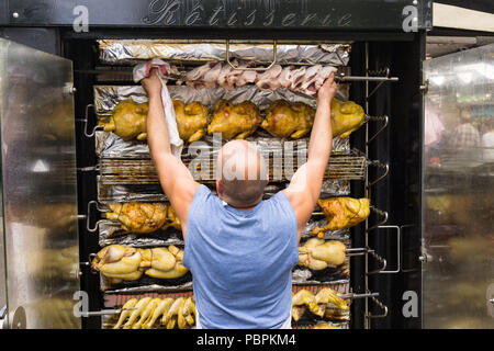 Rotisserie Arbeiter - Mann kochen Hähnchen auf horizontale Spieß rösten (horizontale Rotisserie) bei Farmers Market in Paris, Frankreich, Europa. Stockfoto