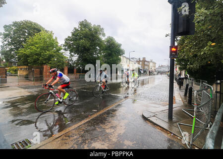 London, Großbritannien. 29. Juli 2018. Radfahrer durch Wimbledon Village in der aufsichtsrechtlichen London Surrey 100 Classic Event in nassen Bedingungen wie die Regenzeit, unten zu kommen. Die aufsichtsrechtlichen Fahrt London-Surrey 100 in seiner sechsten Jahr feiert das Vermächtnis für die London 2012 die Olympischen und Paralympischen Spiele erstellt Radfahren und folgt einer 100km Route auf geschlossenen Straßen durch das Kapital und in die Landschaft von Surrey Credit: Amer ghazzal/Alamy leben Nachrichten Stockfoto