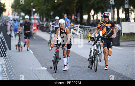 Hamburg, Deutschland. 29. Juli, 2018. Triathlon, Ironman World Series: Triathleten ihre Fahrräder durch den Übergangsbereich. Credit: Daniel Reinhardt/dpa/Alamy leben Nachrichten Stockfoto
