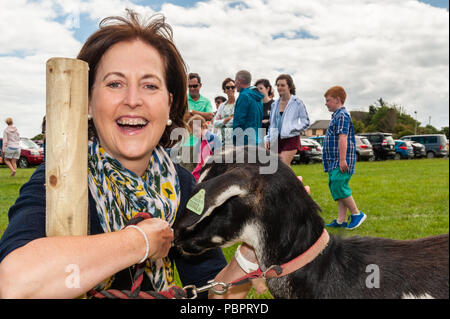 Schull, West Cork, Irland. Juli 2018. Die Schull Agricultural Show ist in strahlendem Sonnenschein mit Hunderten von Besuchern unterwegs. Eine der vielen Attraktionen ist eine Tierfarm - Eunice Bellanger aus Paris hat sich mit einer Ziege aus der Nähe und persönlich kennengelernt. Quelle: AG News/Alamy Live News. Stockfoto