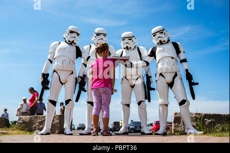 Wilhelmshaven, Deutschland. 29. Juli, 2018. Kleine Emma nähert sich vier "Sturm Troopers" (von der 'Star Wars' Film Franchise) Spenden sammeln für das Meer Retter während der Deutschen Maritime Rescue Tag (DGzRS). Credit: mohssen Assanimoghaddam/dpa/Alamy leben Nachrichten Stockfoto