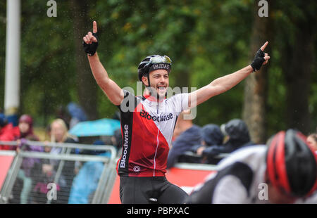 London, UK, 29. Juli 2018. Prudential Fahrt London-Surrey 100. Reiter feiern Überqueren der Ziellinie auf der Mall im Regen am Ende der London - Surrey 100, die sieht 26.000 amateur Radfahrer auf eine Cycling Challenge wie kein anderer durch London und Surrey Nehmen auf einer ähnlichen Route wie die 2012 in London olympische Straßenrennen, als Teil des aufsichtsrechtlichen RideLondon Festival der Radfahren Wochenende. @ David Rebhuhn/Alamy leben Nachrichten Stockfoto