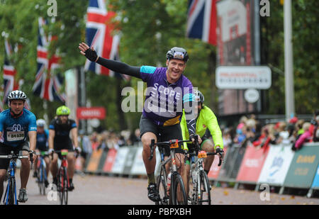 London, UK, 29. Juli 2018. Prudential Fahrt London-Surrey 100. Reiter feiern Überqueren der Ziellinie auf der Mall im Regen am Ende der London - Surrey 100, die sieht 26.000 amateur Radfahrer auf eine Cycling Challenge wie kein anderer durch London und Surrey Nehmen auf einer ähnlichen Route wie die 2012 in London olympische Straßenrennen, als Teil des aufsichtsrechtlichen RideLondon Festival der Radfahren Wochenende. @ David Rebhuhn/Alamy leben Nachrichten Stockfoto