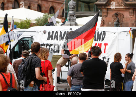 Wiesbaden, Deutschland. 29. Juli 2018. Rechtsradikale Demonstranten hören den Reden. Rechtsextreme Demonstranten der Hand in Hand-Gegen die Gewalt in unseren Strasen (Hand in Hand - gegen Gewalt auf unseren Straßen) Bewegung statt einer regierungsfeindlichen Kundgebung in Wiesbaden. Dieser Protest war unter dem Vorwand, eine Mahnwache für den Jugendlichen Susanna F, der angeblich von einem Flüchtling in Wiesbaden getötet wurde. Die Kundgebung wurde von mehreren Anti-government Referenten, die forderte, dass die Regierung zum Rücktritt gerichtet. Stockfoto