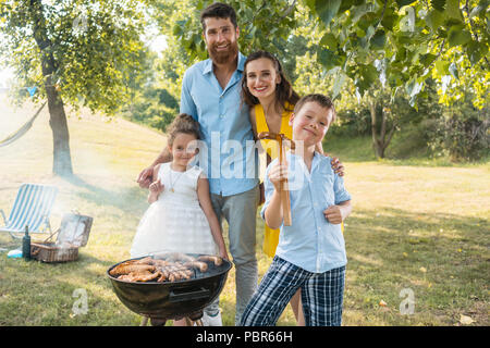 Portrait der glücklichen Familie mit zwei Kindern stehen im Freien Stockfoto