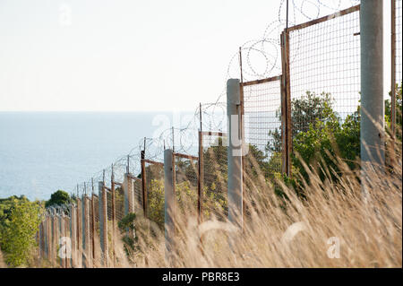 Staatsgrenze razor Stacheldraht und Zaun entlang Meer und Wald Gefahrenbereich Stockfoto