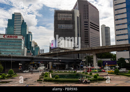 Bangkok, Thailand - 1. Mai 2018: verkehrsreichen Kreuzung zwischen Silom Skytrain Station und Lumphini Park von Wolkenkratzern umgeben Stockfoto